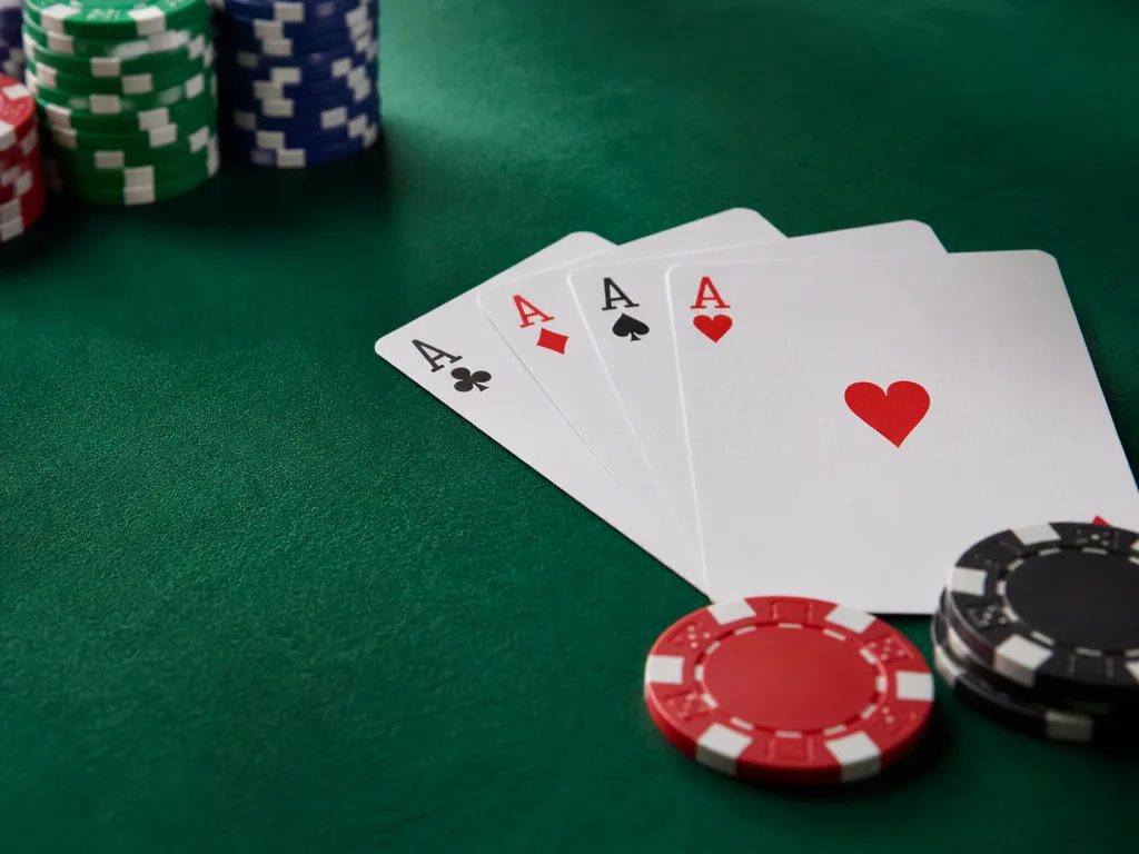 Grön pokerbordsmatta med spelkort och casinochips arrangerade i mjukt studioljus